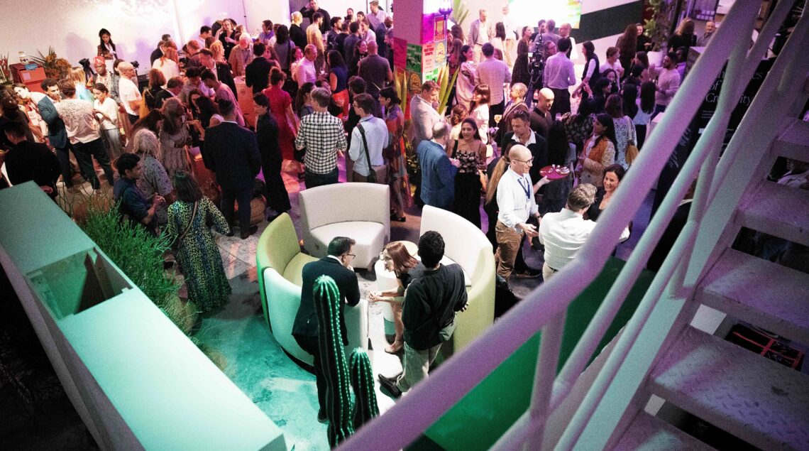 People gathered in a space with purple and green lights